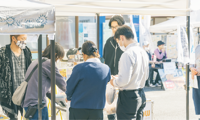 就労継続支援B型事業所・YELLOWの利用者さんが自身の作品を販売しお客さんと言葉を交わしている様子