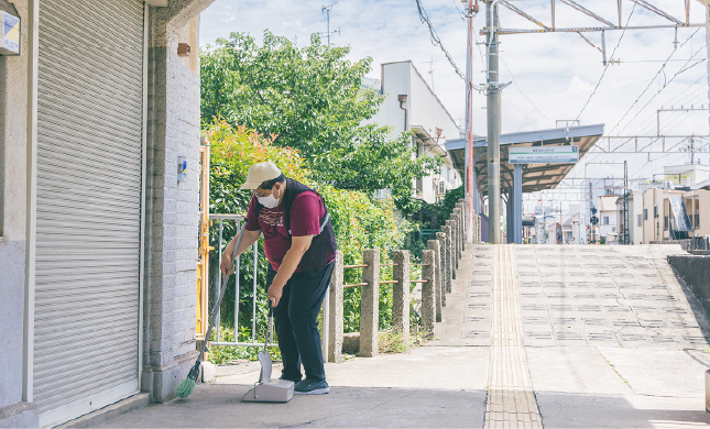 総合就労支援福祉施設・にしなりWingの利用者さんが西天下茶屋駅の駅構内で掃き掃除する様子